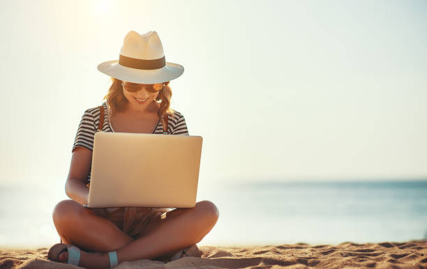 istock young woman working with laptop on nature in beach 1130336500