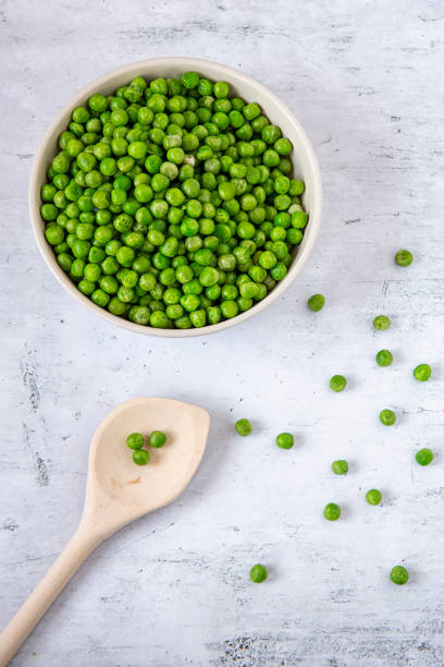 istock Green peas in a plate on the kitchen table 1130336583