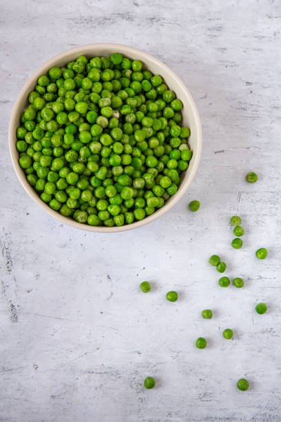 istock Green peas in a plate on the kitchen table 1130336597