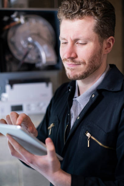 dijital tablet kullanarak merkezi isıtma kazanı bakım erkek isıtma mühendisi - isıtma tesisatı mühendisi stok fotoğraflar ve resimler