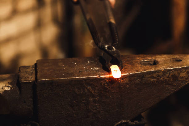 istock The blacksmith manually forging the red-hot metal on the anvil in smithy. 1130338664