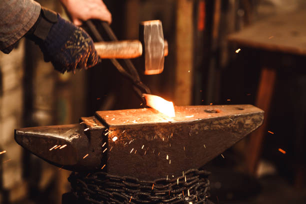 istock The blacksmith manually forging the red-hot metal on the anvil in smithy with spark fireworks. 1130338666
