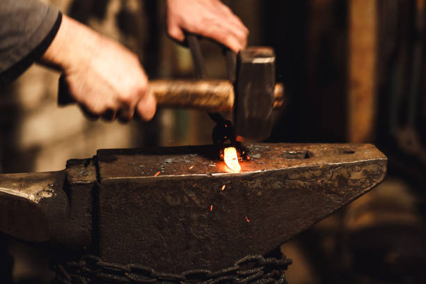 istock The blacksmith manually forging the red-hot metal on the anvil in smithy with spark fireworks. 1130338670