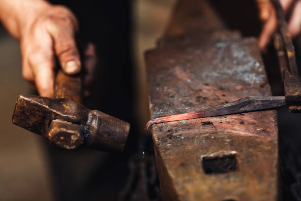 istock blacksmith makes an artistic forging of hot metal on the anvil. 1130338699
