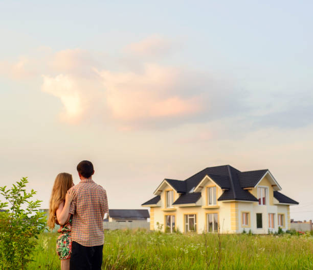 istock Young Couple Standing Outside Dream Home 1130338754