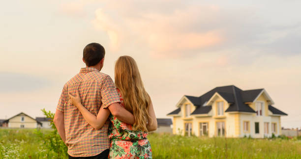 istock Young Couple Standing Outside Dream Home 1130338763