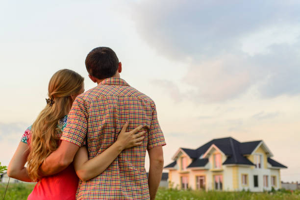 istock Young Couple Standing Outside Dream Home 1130339360