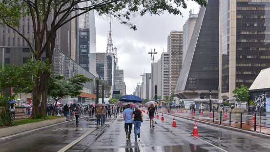 Sao Paulo city, Sao Paulo capital, Brazil - October 22, 2017:People walking on Paulista Avenue on a rainy day.