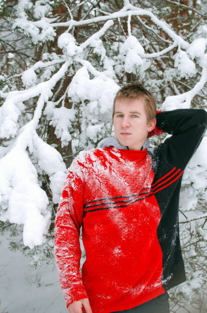 istock guy in the winter forest in a sweater sprinkled with snow 1130348388