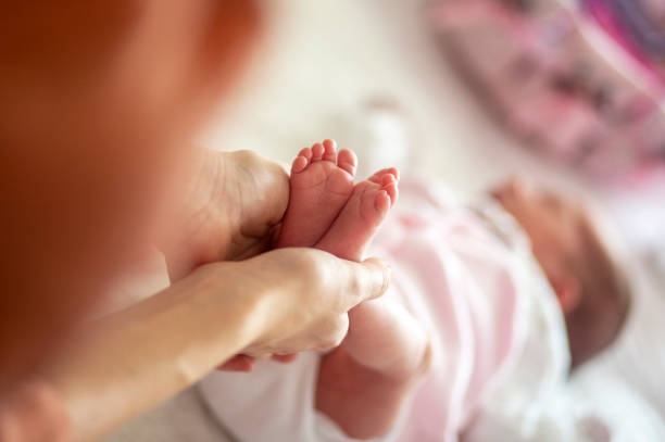istock Baby feet in mother hands 1130348787