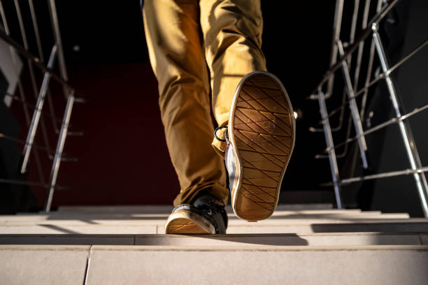 istock bottom view of a young man walking down the stairs 1130350093