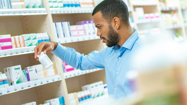 hombre de barba elegir en droguería - pill bottle pharmacy medicine shelf fotografías e imágenes de stock