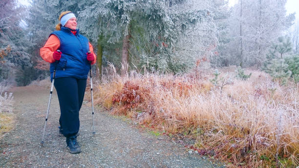 избыточный вес женщина сделала новый год резолюции для потери веса в новом году. тучный турист, идущего по лесной тропе в зимний холод. скан� - nordic walking hiking mountain walking стоковые фото и изображения