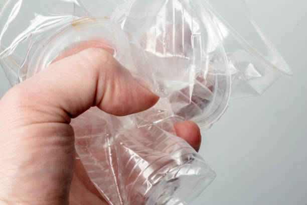 istock Person holds in his hand several used crumpled transparent plastic cups. 1130354670