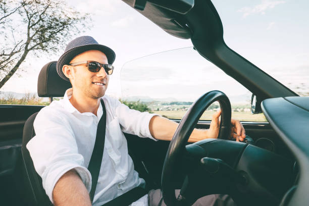 istock Man driving cabriolet car by province mountain road inside car view 1130357783