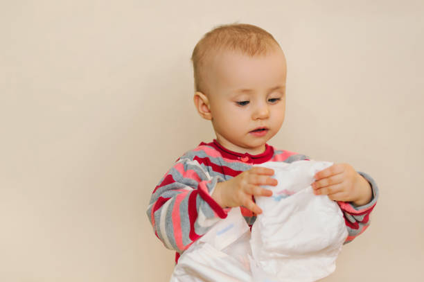 istock baby holding a diaper in hand 1130359312