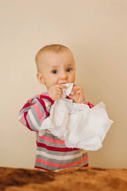 istock baby holding a nappy in mouth and looking 1130359409