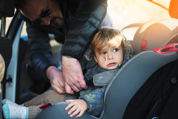Young father putting baby girl in the car stock photo