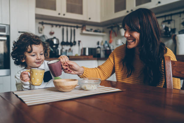 Little boy and mom on the table Cute litlle boy and his smiling mother on the table at home boys bowl haircut stock pictures, royalty-free photos & images
