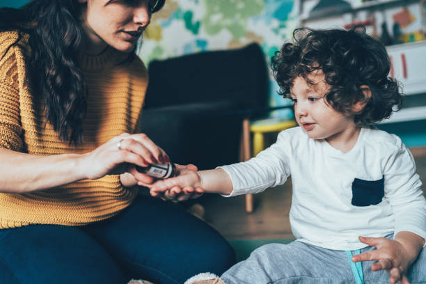 mother giving a medicine to child - homeopatic medicine imagens e fotografias de stock