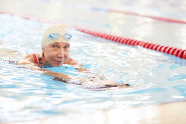 istock Smiling Senior Woman Swimming in Pool 1130365627