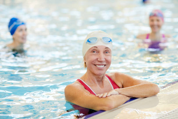 istock Happy Mature Woman Posing in Pool 1130365632