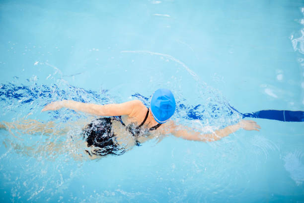 istock Unrecognizable Woman Swimming in Pool 1130365679