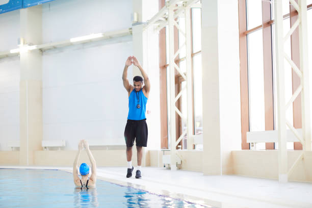 Aqua Aerobic Training with Water Fitness Equipment. Women Training with Swimming Noodles.