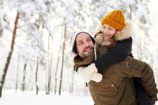 istock Father and Daughter in Winter Forest 1130366572