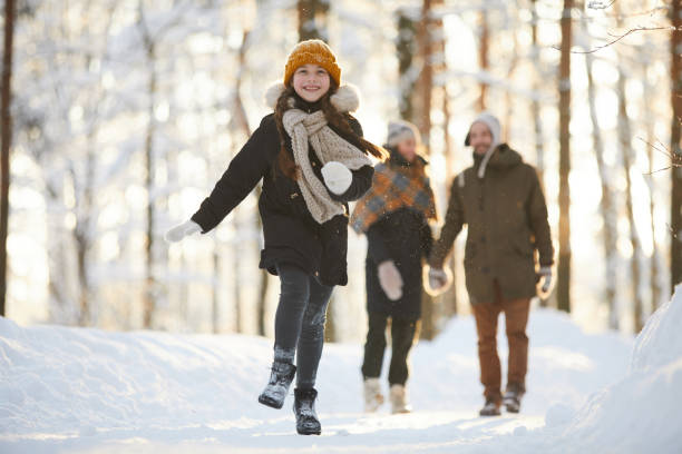 szczęśliwa dziewczyna biegająca w zimowym lesie - family winter walking fun zdjęcia i obrazy z banku zdjęć