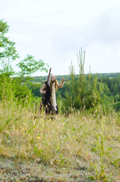 istock young witch is wandering in a meadow among young trees looking for something 1130372040