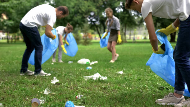 giornata di pulizia organizzata dalla famiglia amichevole per pulire il parco della spazzatura domestica - trash day foto e immagini stock