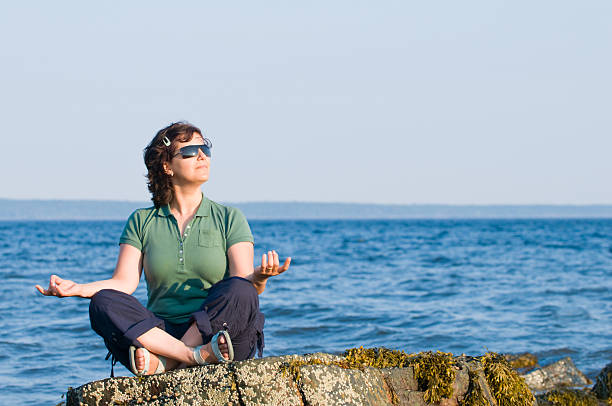 istock Young woman meditating on the beach 113037546