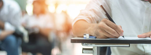 школьный экзамен студент принимает образовательный вступительный тест в классе, думать трудно, писать ответ в университетском классе, обр� - экзамен стоковые фото и изображения