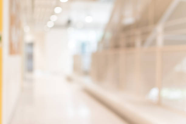 istock Corridor in school or office building blur background with blurry interior view empty hall way, glass curtain wall and floor with exterior light illumination 1130379630