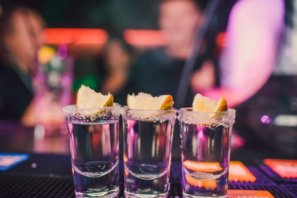 aperitif mit freunden in der bar, pfeffer fünf gläser alkohol mit snacks kalk und pistazien, salz und chili für die dekoration. tequila shots, wodka, whisky, rum. selektiven fokus und kopie raum. - tequila slammer stock-fotos und bilder