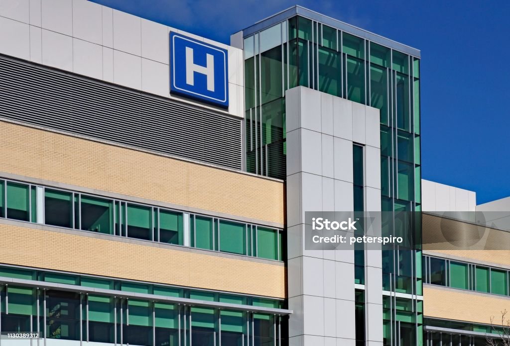 edificio con gran cartel de H para el hospital - Foto de stock de Hospital libre de derechos