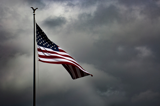 Dramatic clouds frame an American flag.