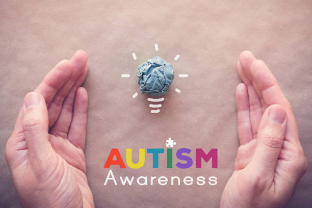 istock Blue paper light bulb and puzzle with hands, world Autism awareness day 1130393749