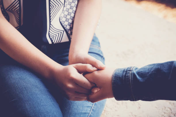 istock young women holding hands for comfort 1130393846