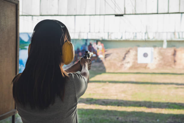 giovane donna pratica sparare pistola sul bersaglio - handgun foto e immagini stock