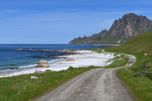 A winding, gravel road works it's way along the stunning coastline near Bleik on the island of Andoya in Norway's Vesteralen Islands.