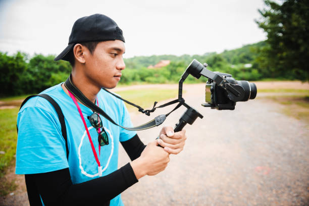 istock Young man holding camera shooting video at outdoor 1130405055