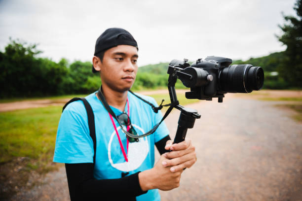 istock Young man holding camera shooting video at outdoor 1130405059