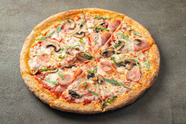 istock Delicious hot pizza with ham and champignons. 1130406742