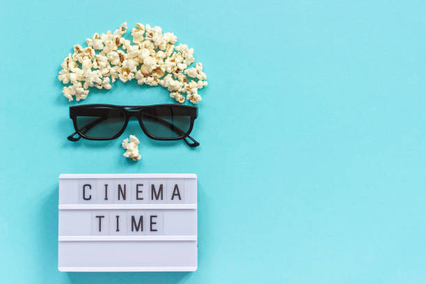 istock Abstract image of viewer, 3D glasses, popcorn and light box text Cinema time on blue paper background. Concept cinema movie and entertainment Flat lay Top view Copy space for text or your design 1130406856