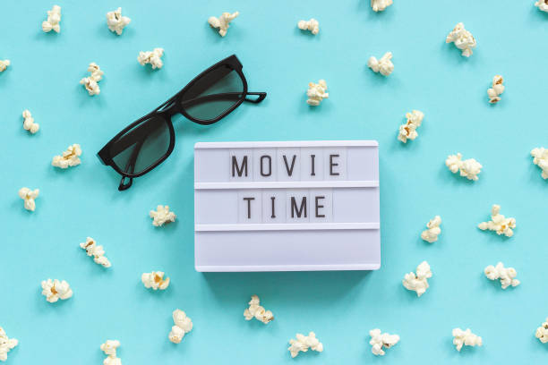 istock 3D glasses, popcorn and lightbox text Movie time on blue paper background. Top view Template Concept cinema movie and entertainment 1130406861