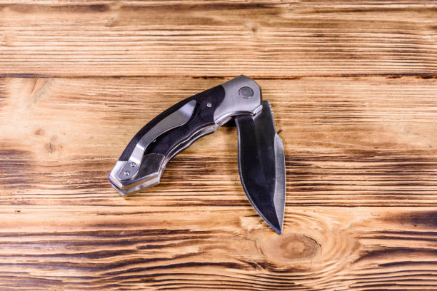 istock Opened folding knife on a wooden table 1130407881