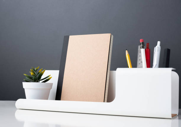 istock notebook on modern office stationery on white table.pencil, notepad,ruler,pen and pencil box with plant.Mock up paper note for display of design or content. 1130408749