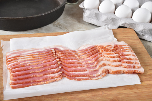 A slab of organic uncured bacon slices on a cutting board